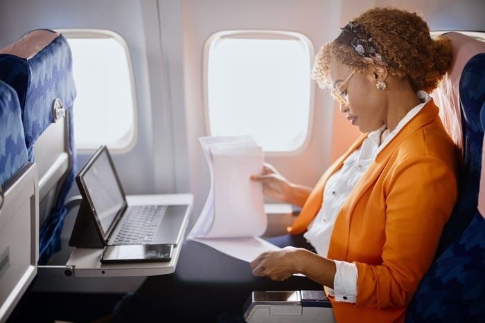 Forretningsrejsende arbejder på laptop under en flyrejse